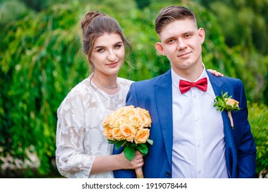 Groom In A Bright Blue Suit And Red Bow Tie On A Walk In A Summer Park