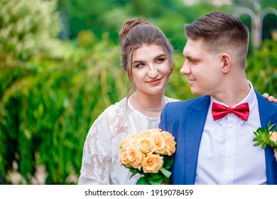 Groom In A Bright Blue Suit And Red Bow Tie On A Walk In A Summer Park