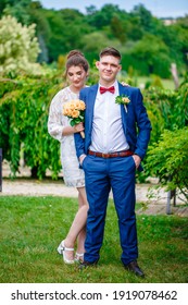 Groom In A Bright Blue Suit And Red Bow Tie On A Walk In A Summer Park