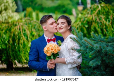 Groom In A Bright Blue Suit And Red Bow Tie On A Walk In A Summer Park