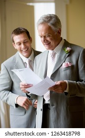 Groom And Father Of The Bride Rehearsing Speech On Wedding Day