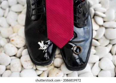 Groom Getting Ready With A Red Tie, His Wedding Band, Red Pocket Square, And Cufflinks