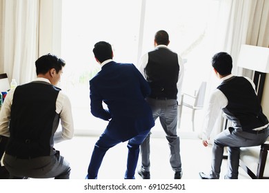 Groom And Groomsmen Dance Before A Window In The Hotel Room