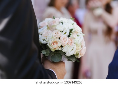 A groom holding a beautiful wedding bouquet closeup