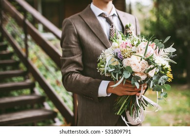 Groom Holding A Unique Wedding Bouquet With Protea And Other Bright Flowers