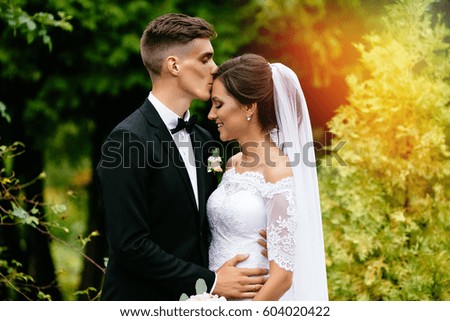 The groom kisses his sweetheart bride at their wedding after ceremony. Wedding day