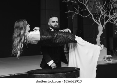 The Groom Is The Magician And The Bride Is The Assistant. The Game Of The Newlyweds. Black And White Photo.
