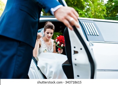 Groom Open Door Of Limousine And Take Hand To Bride