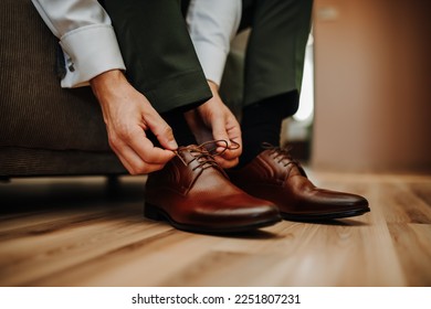 Groom puts on his wedding shoes