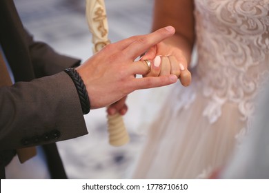 Der Bräutigam legt den Ring auf den Finger der Braut in Nahaufnahme