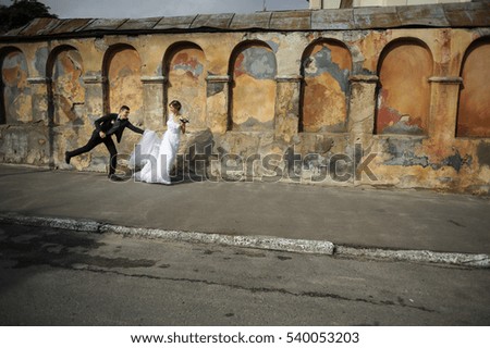 Similar – Woman in wedding dress with two men on a rope