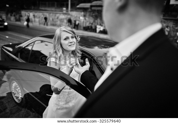 Groom sitting bride at
car