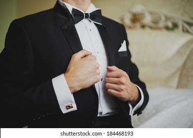 groom straightens his jacket