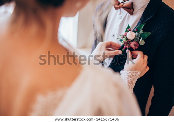 the\
groom in a suit straightens his tie bubochku. boutonniere on the\
lapel of his jacket. young man in a business\
suit.