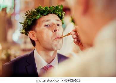 Groom Takes Holy Communion From Priest's Hand