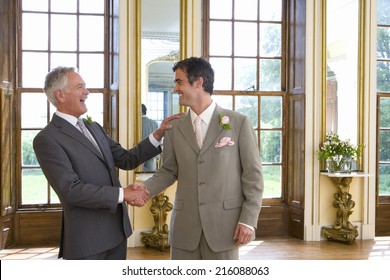 Groom And Usher Shaking Hands, Smiling At Each Other, Side View