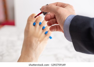 Groomed Male Hand Painting Nail Polish To Woman Foot Fingernails