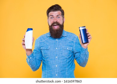 Grooming At Every Opportunity. Bearded Man Hold Shampoo Bottles Yellow Background. Cosmetics And Toiletries. Hygiene And Personal Grooming. Male Body Grooming And Skincare. Grooming Products For Men.