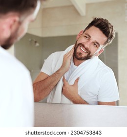 Grooming, face and mirror for man with skincare and self care routine in a bathroom with a smile. Home, reflection and cleaning with a young male person feeling happy from beard growth or dermatology - Powered by Shutterstock