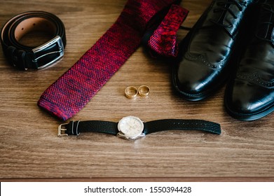 Groom's black men shoes, tie, belt, watch and rings on table. Accessories men. Wedding preparation morning of the groom.