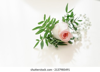 Groom's boutonniere on the wedding day. Wedding accessories from natural flowers. Rose boutonniere