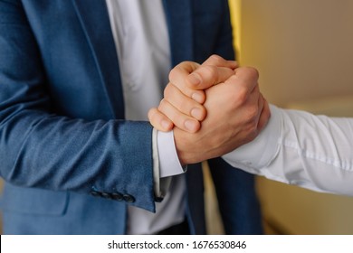 Groomsmen shakes hands with the groom and helping happy groom getting ready in the morning for wedding ceremony. Groom wedding preparation. Close-up - Powered by Shutterstock