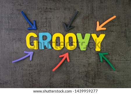 Groovy modern programming language for software development or application concept, multi color arrows pointing to the word Groovy at the center of black cement chalkboard wall.