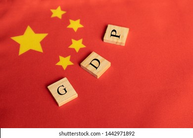 Gross Domestic Product Or GDP Of China On Wooden Block Letters On Chinese Flag