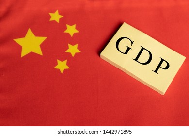 Gross Domestic Product Or GDP Of China On Wooden Block Letters On Chinese Flag