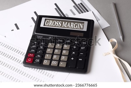 GROSS MARGIN text on a calculator with chart on grey background