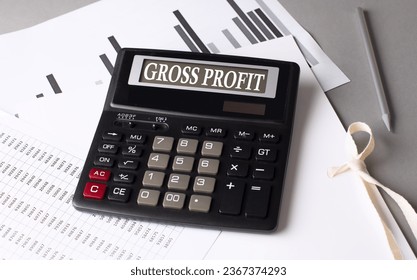 GROSS PROFIT text on calculator with chart on a grey background