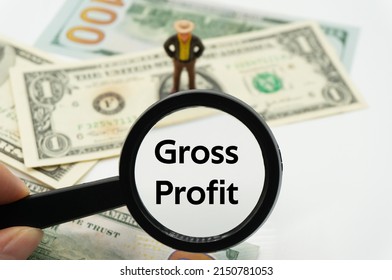 Gross Profit.Magnifying glass showing the words.Background of banknotes and coins.basic concepts of finance.Business theme.Financial terms. - Shutterstock ID 2150781053