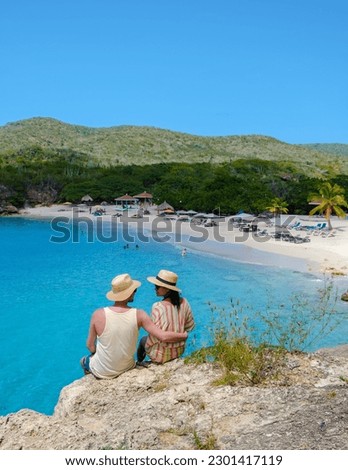 Grote Knip Beach Curacao Island, a Tropical beach on the Caribbean island of Curacao Caribbean. A couple of men and woman on vacation in Curacao walking at the beach