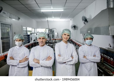 Groub workers in production line at drinks production factory background - Shutterstock ID 1989436004