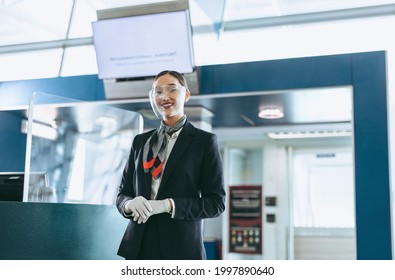 Ground Attendant With Face Shield Standing At Airport. Airport Staff During Pandemic Waiting For Passengers.