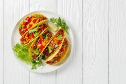 Ground Beef Tacos With Shredded Cheddar Cheese, Fresh Lettuce, Tomato, Onion On A White Plate With Lime Wedges, Horizontal View From Above, Mexican Cuisine, Flat Lay, Free Space