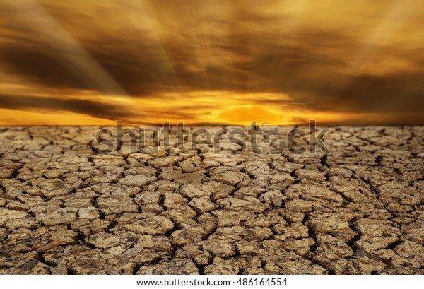 The Ground Cracked Soil In Summer With Dramatic Sunset, Selective Focus.