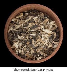 ground dried angelica  in wooden cup isolated on black background. top view