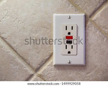 Ground fault interrupter electricity receptacle and wall plate. Residential electric socket plug with GFI reset button.