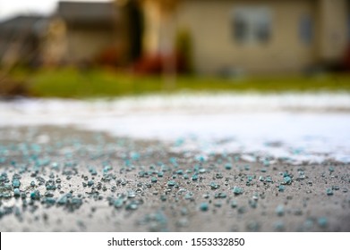 Ground Level Closeup View Of Rock Salt Ice-melt  On Concrete With Snow