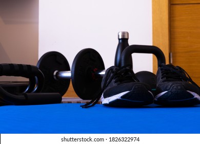 Ground Level Photography Of Sports Equipment, Dumbbells, Sneakers, Kettlebell, Water Bottle And Push-up Accessory, All On A Mat For Sports At Home