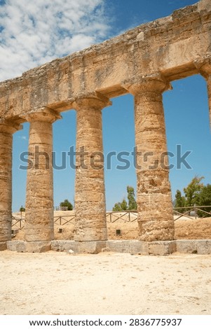 Ground level vertical view of ancient Greek Doric columns and architrave in Segesta, Sicily, Italy