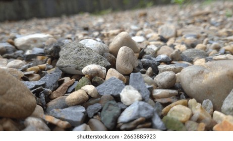 Ground level view of assorted river stones and gravel creating a natural textured background landscape perfect for digital design and creative projects