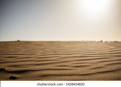 Ground Level View Of Desert Sand At Sunset With Sun Hitting Hard From Above Giving A Sense Warm And Hot Wth Nobody