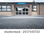 Ground level view of a patient zebra crossing leading to the entrance of a typical NHS hospital in Britain. The building is for outpatient care.