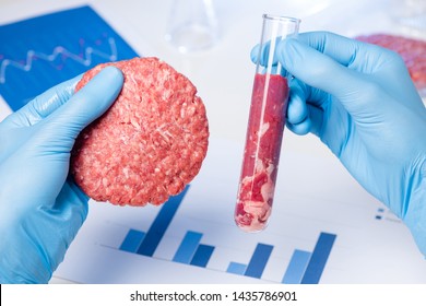 Ground meat sample burger patty in lab scientist hand. Clean artificial cultured meat in laboratory test tube concept.