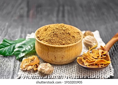 Ground nutmeg in a bowl and dried nutmeg arillus in a spoon, whole nuts on burlap napkin on dark wooden board background - Powered by Shutterstock