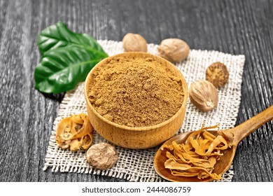 Ground nutmeg in a bowl and dried nutmeg arillus in a spoon, whole nuts on burlap napkin on black wooden board background - Powered by Shutterstock