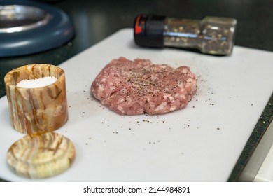 A Ground Pork Breakfast Sausage Patty Being Prepared On A Cutting Board With Salt And Pepper 