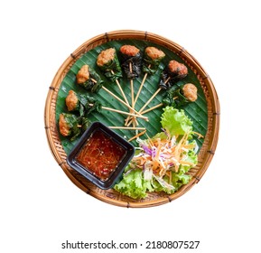 Ground Pork Wrapped In Betel Leaves, Skewed On A Stick And Then Fried On Bamboo Platters With Sauce Isolated On White Background